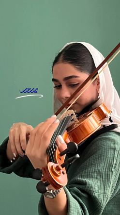هنرجوی ویلن در حال تمرین موسیقی حرفه ای زیر نظر استاد ویلن در بابل. محیط آموزشی آرام و حرفهای آموزشگاه پرند در تصویر کاملاً مشخص است تمرین ویولن با هنرجویان آموزشگاه پرند